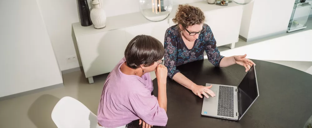 adviseur toont op computerscherm waar informatie terug te vinden is 