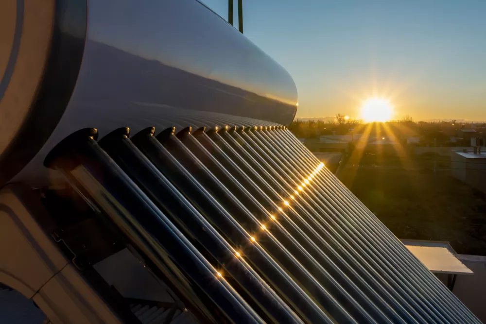 ondergaande zon met zicht op zonneboilercollectoren